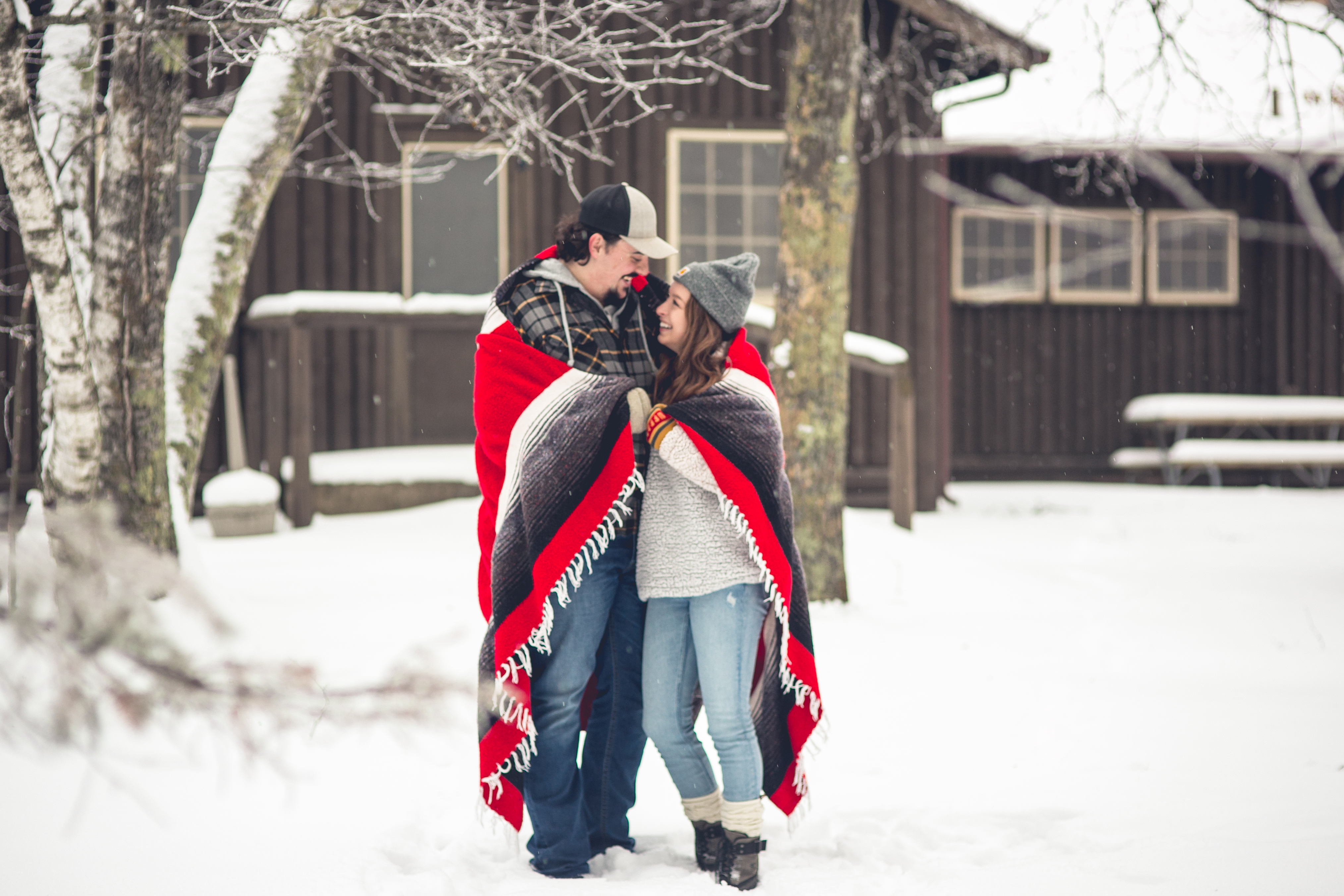 MN Snow Engagement Photos with Diamond Ring, Jeans, Boots, Hats and a Red Blanket