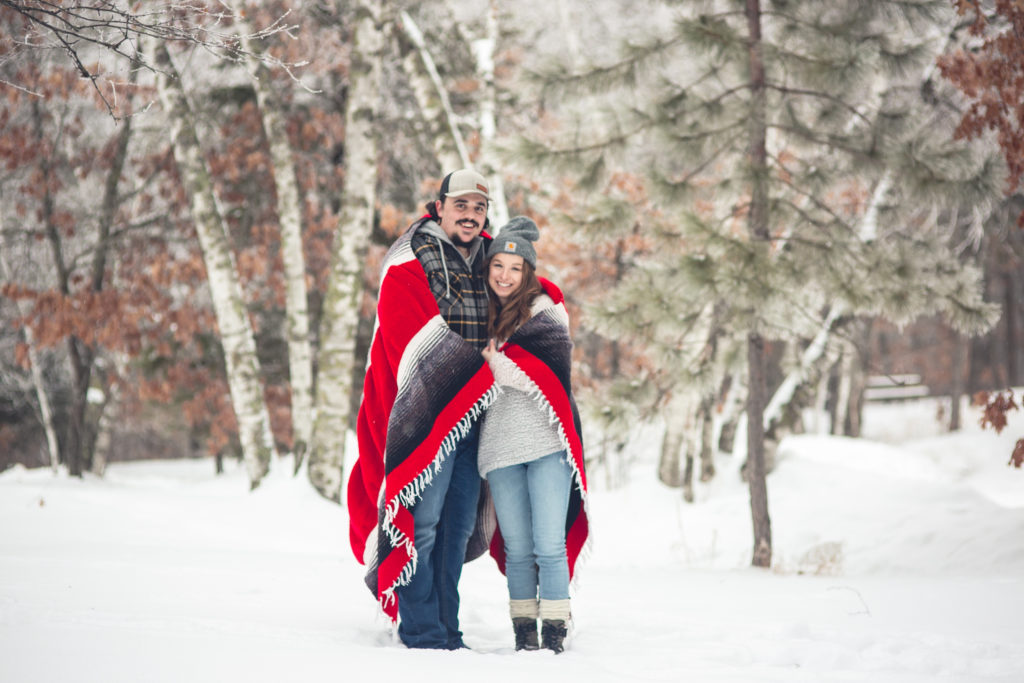 Bride wearing Sherpa Fleece and a Red Blanket Wrap, Over Jeans for Snowy Engagement Session at State Park. Flannel