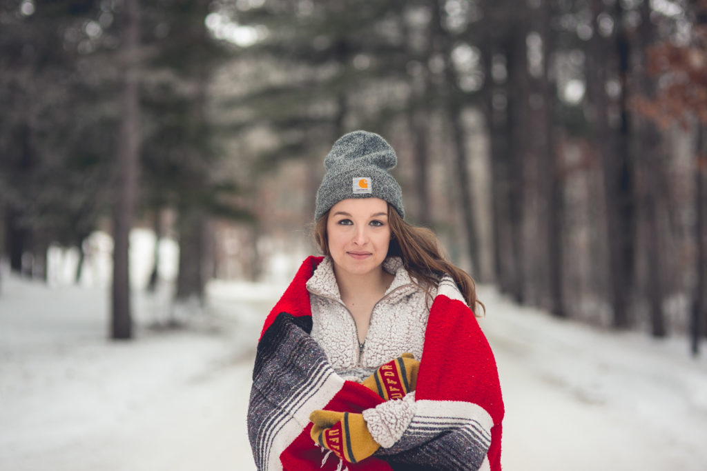 Red Blanket, Pine Trees, Carhartt Beanie, Sherpa Sweater, Uufta MN mittens in Bemidji. She's wearing Jeans and he wore jeans and a flannel. Long Brown Hair Engagement Couple Session